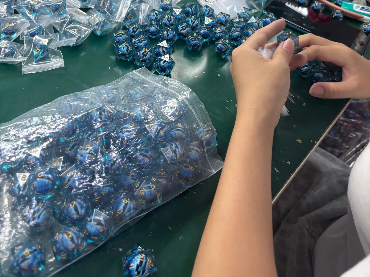 Factory workers inspecting and sorting finished blue polyhedral dice