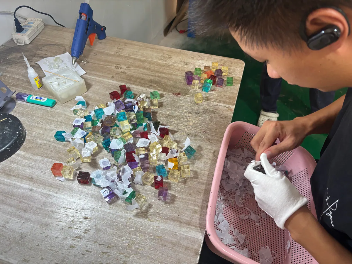 Worker preparing master models for custom resin dice molds